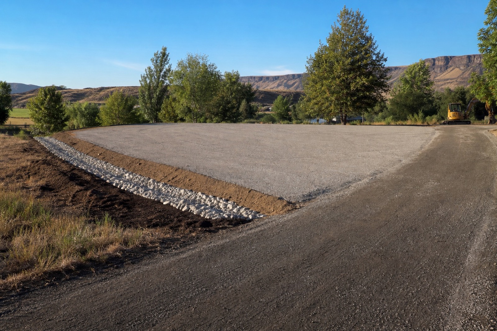 Excavator grading a rural residential property near Twin Falls